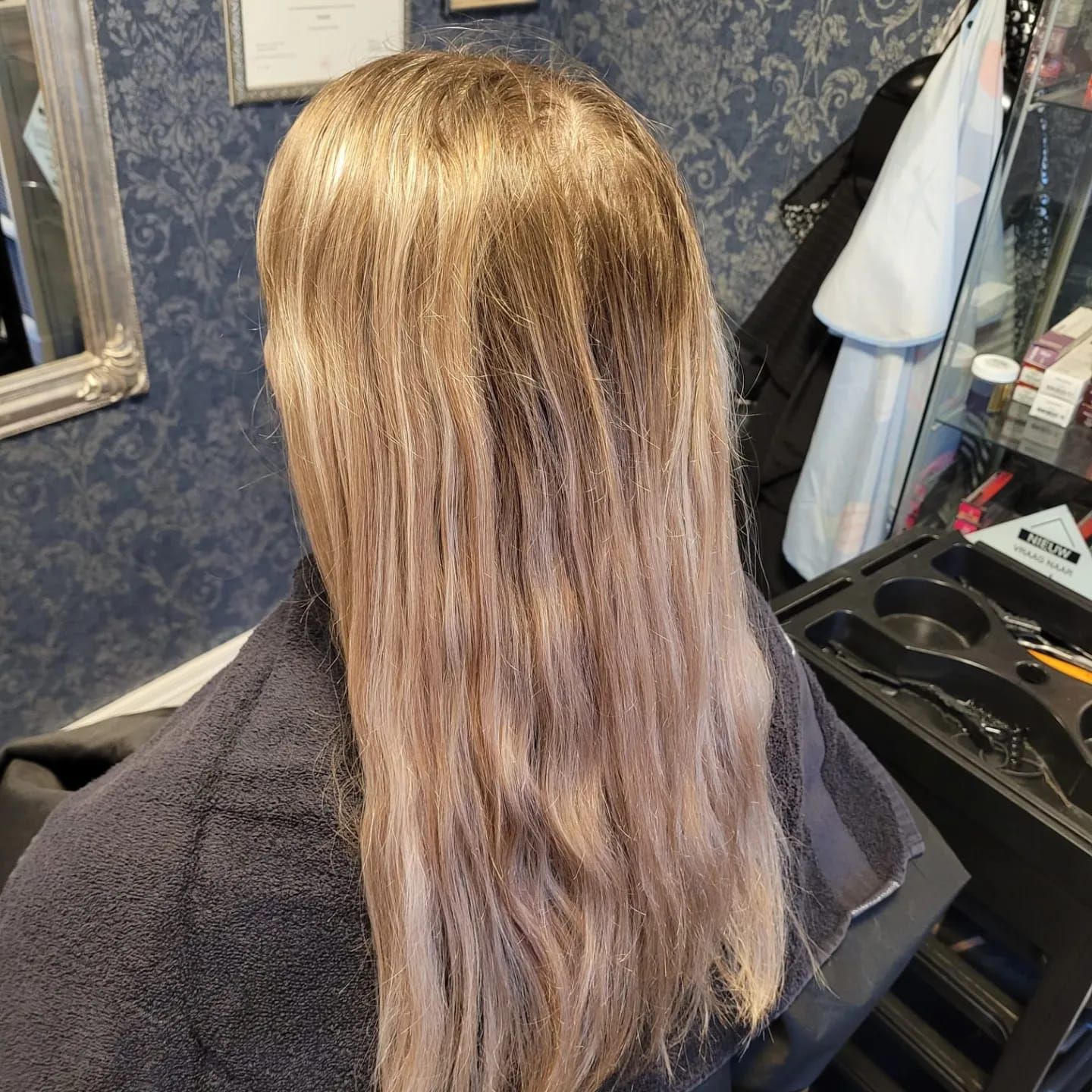 Lang warm blond haar na een kleurbehandeling in de salon