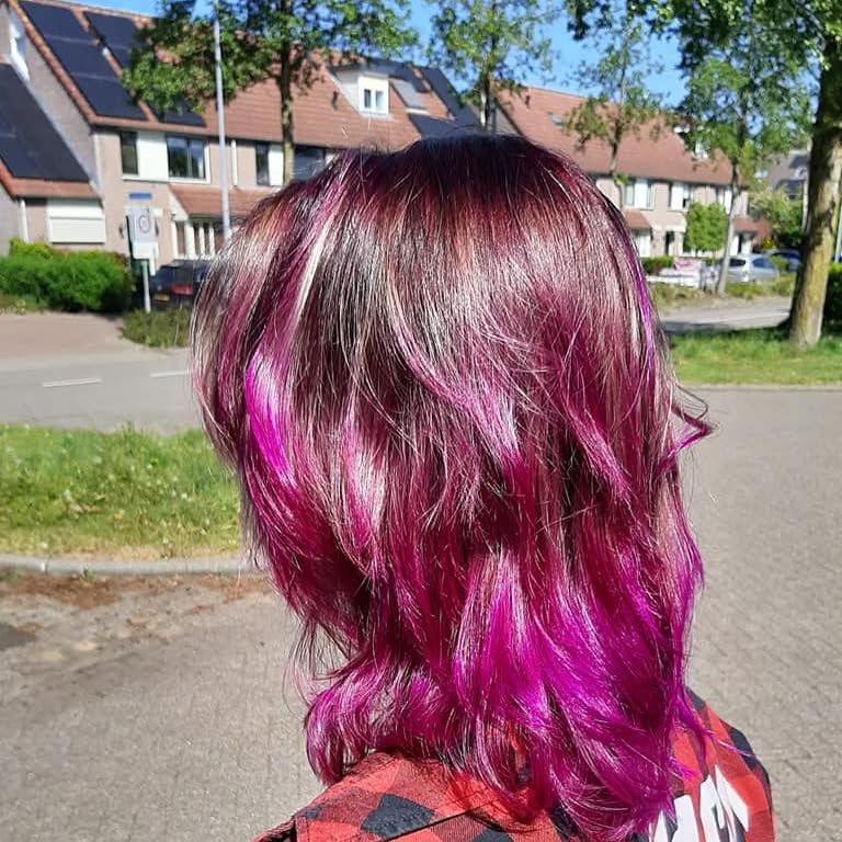 Halflang haar in een uitgesproken magenta kleur